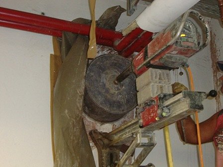 Kernbohrung mit einer an der Wand befestigten Hilti-Bohrmaschine samt Schutzfolie