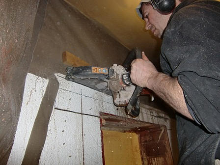 Arbeiter sägt mit Betonsäge Ziegelwand